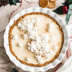 Eggnog custard pie topped with whipped cream and nutmeg.