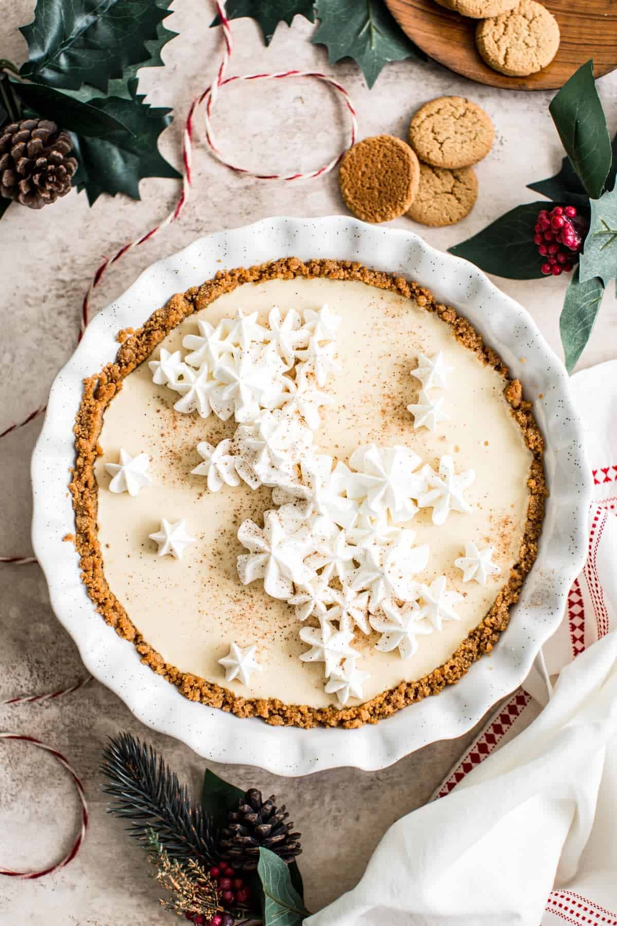 Eggnog custard pie topped with whipped cream and nutmeg.