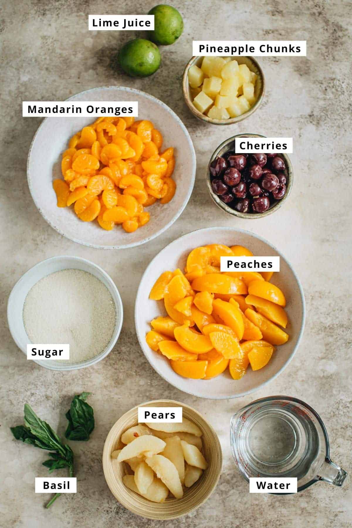 Fruit cocktail salad ingredients in various bowls.