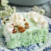 Vintage lime jello salad topped with whipped cream.