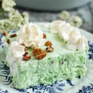 Vintage lime jello salad topped with whipped cream.