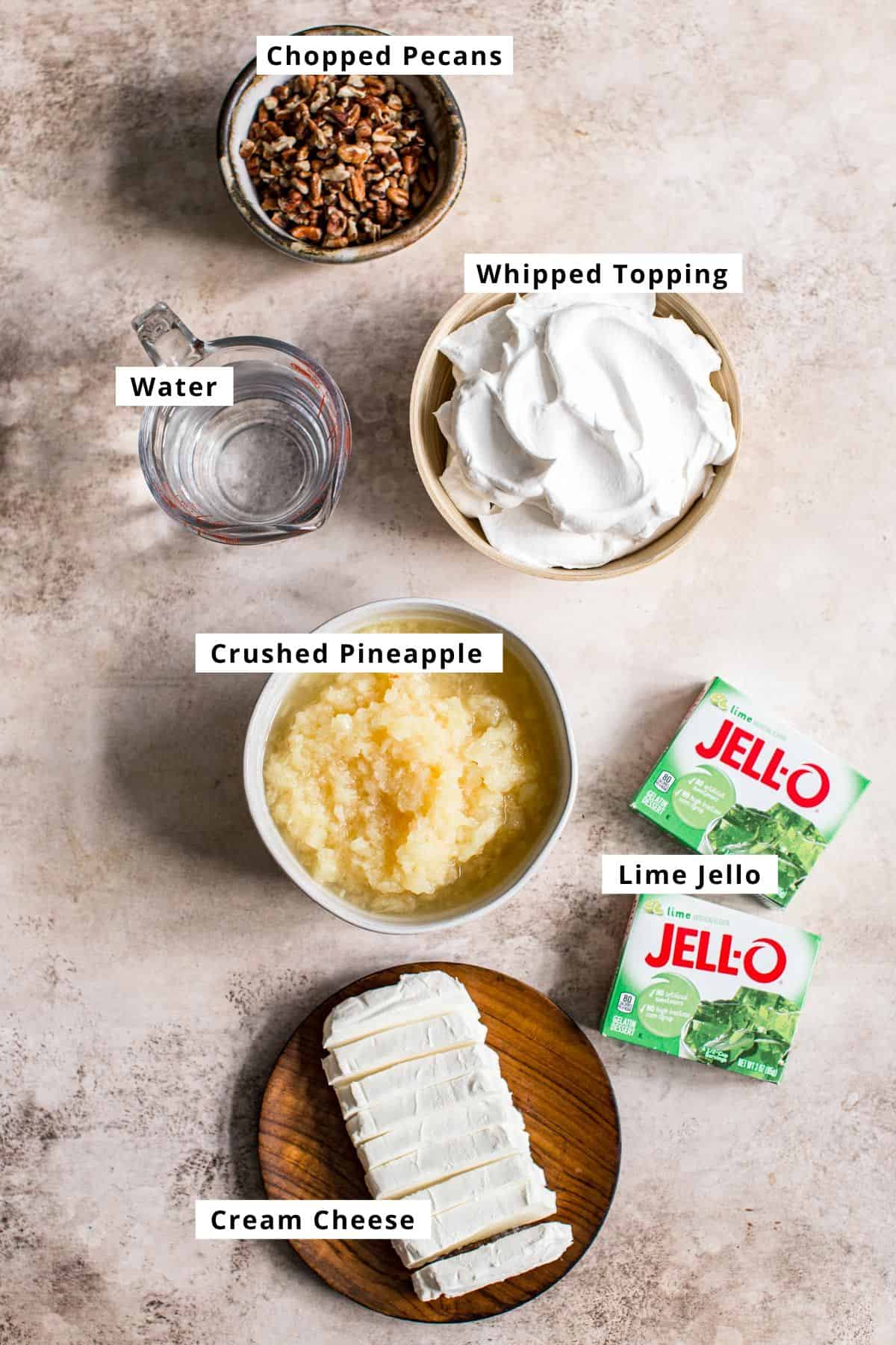 Vintage lime jello salad ingredients in various bowls.