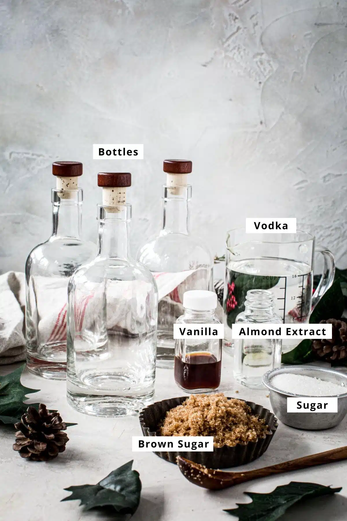 Amaretto recipe ingredients in bottles and bowls with ingredient name labels.