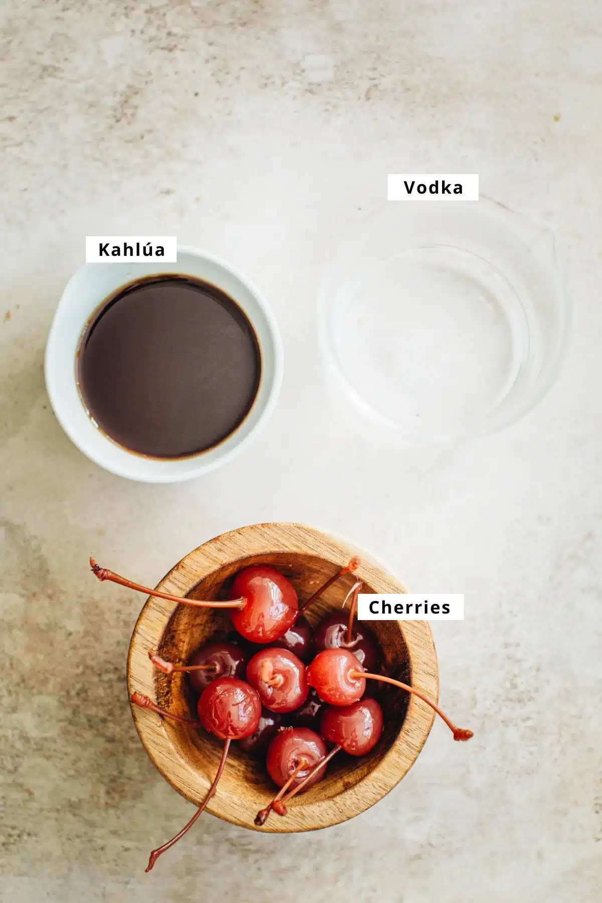 Black Russian recipe ingredients in bowls and glasses.