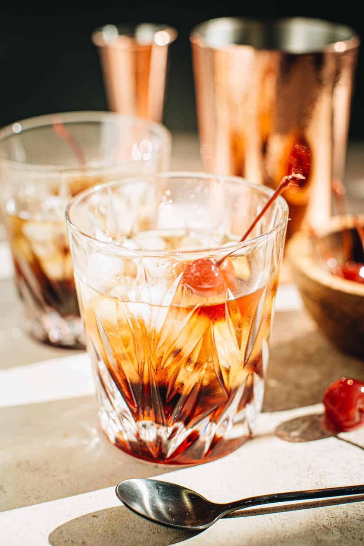 Black Russian in a rocks glass with a cherry garnish.