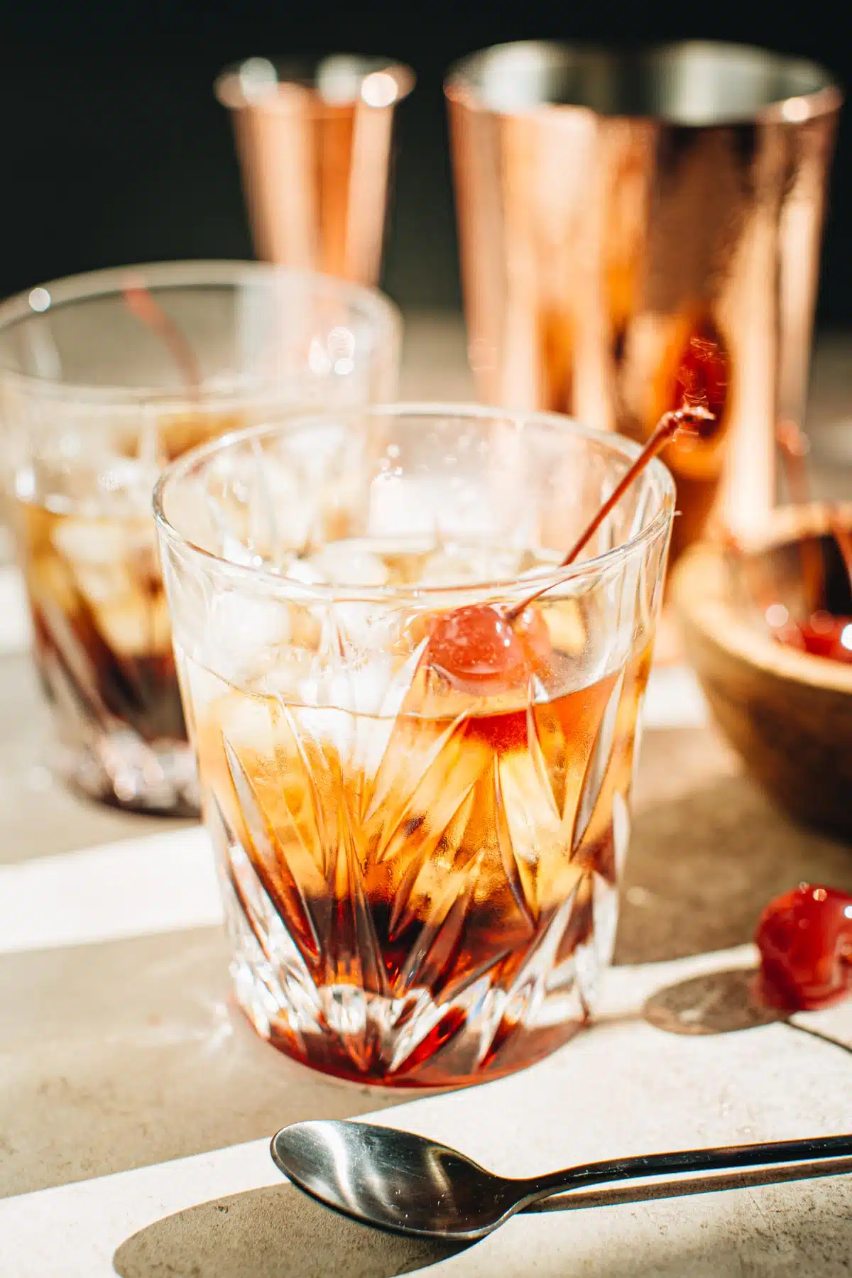 Black Russian in a rocks glass with a cherry garnish.