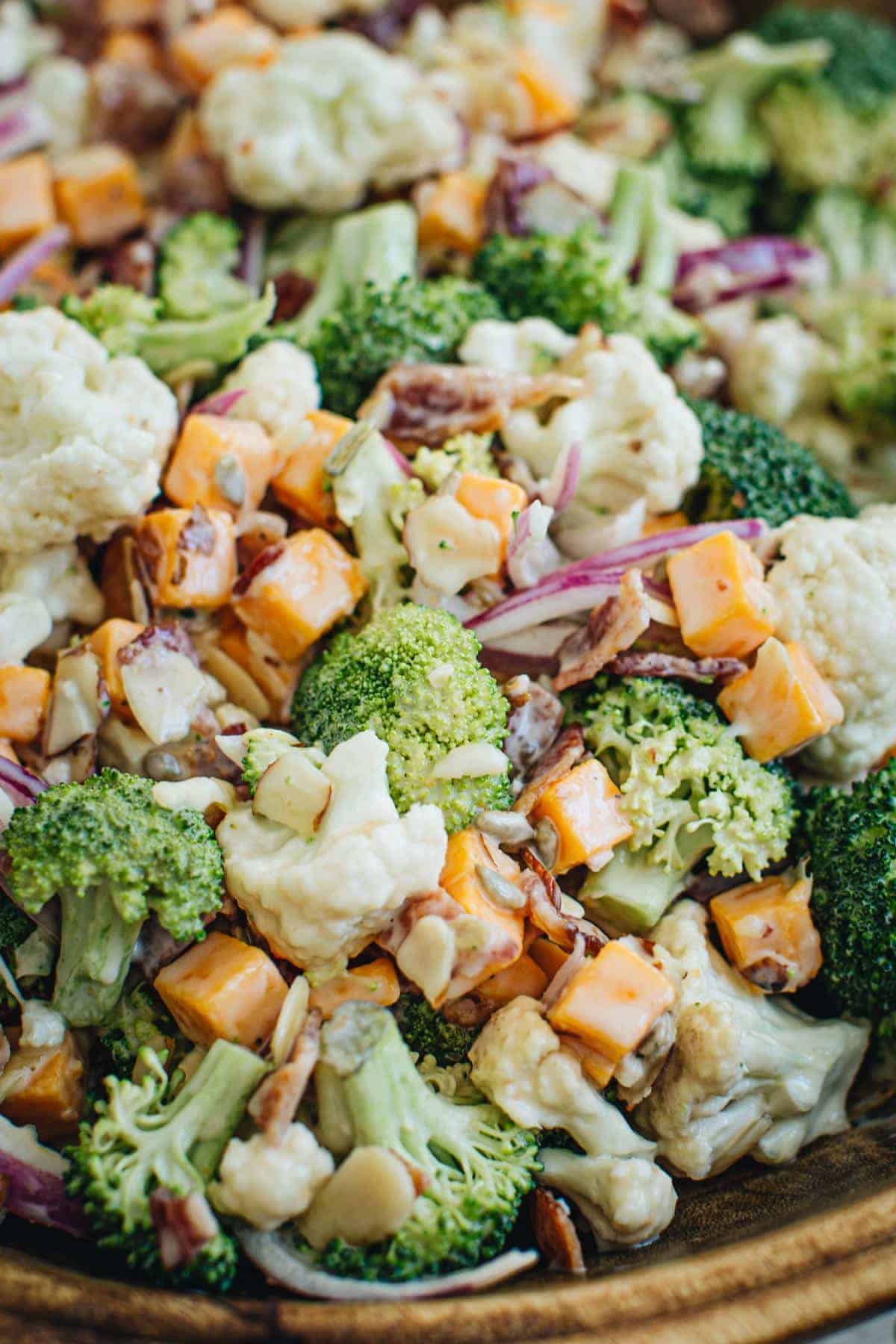 Broccoli cauliflower salad with a mayonnaise dressing in a wooden bowl.