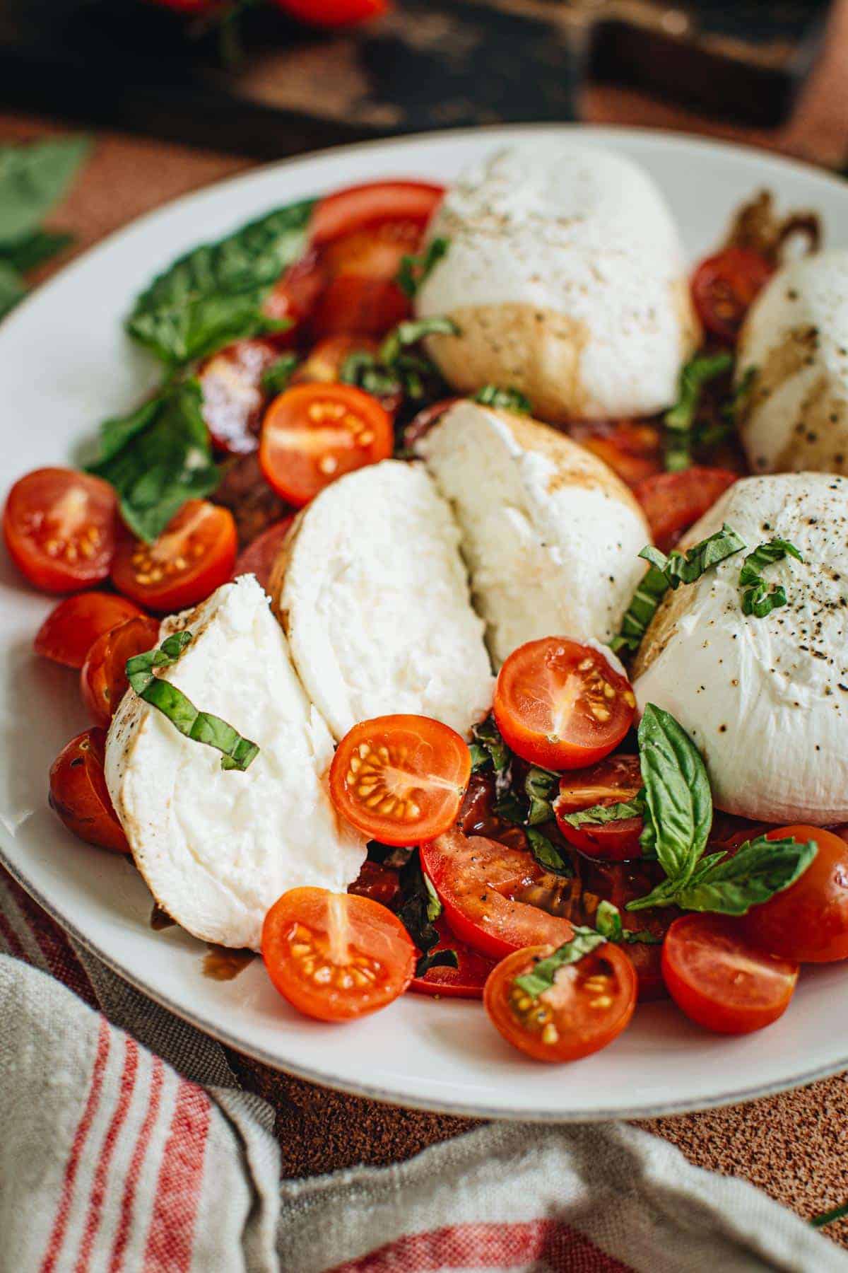 Burrata Caprese salad with fresh basil on top.