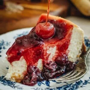 Slice of cherry cheesecake with a cherry on top.