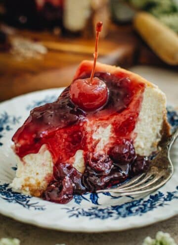 Slice of cherry cheesecake with a cherry on top.