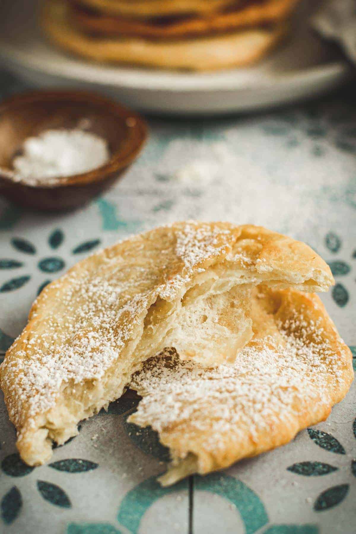 Torn fried bread dusted with powdered sugar.