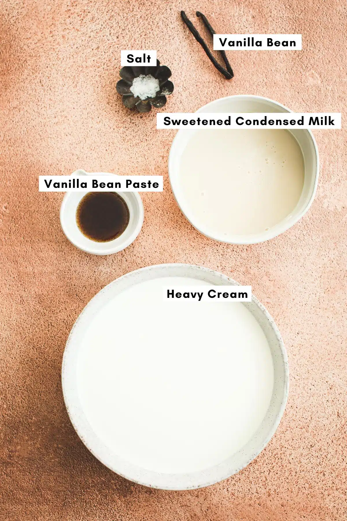 Homemade vanilla bean ice cream ingredients in various bowls.