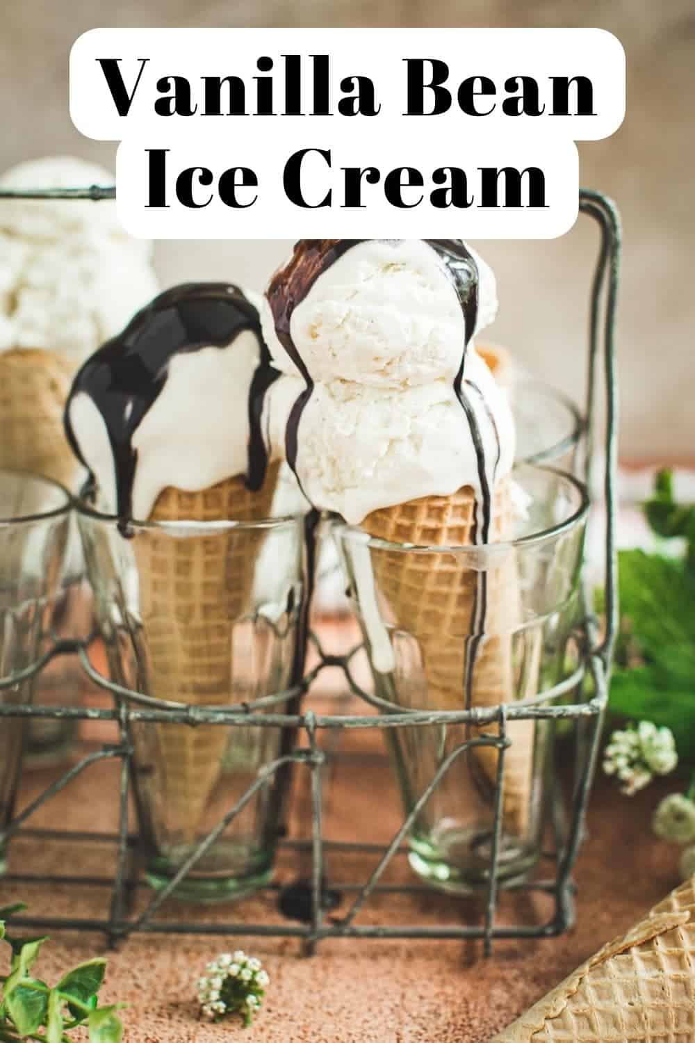 Homemade vanilla bean ice cream on cones with chocolate syrup drizzled on top.