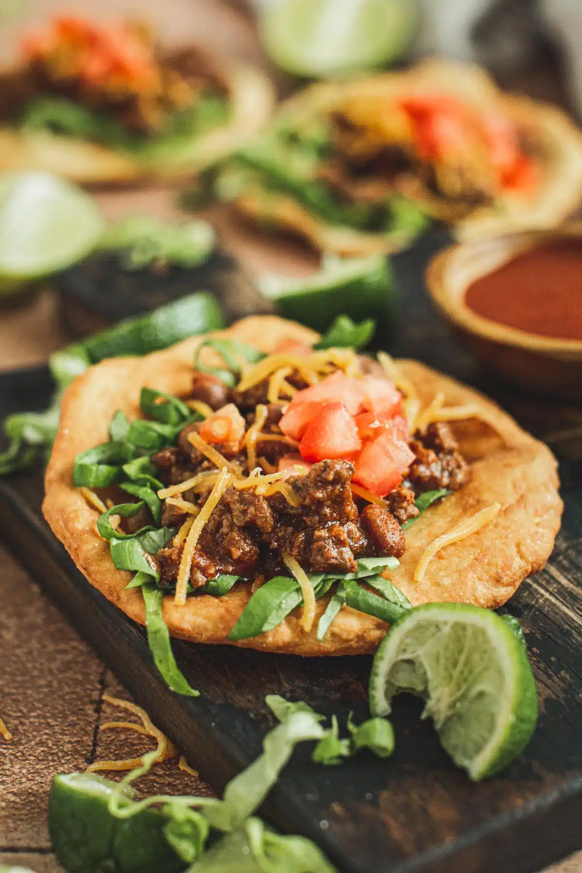 Indian tacos on fry bread sitting on a board.