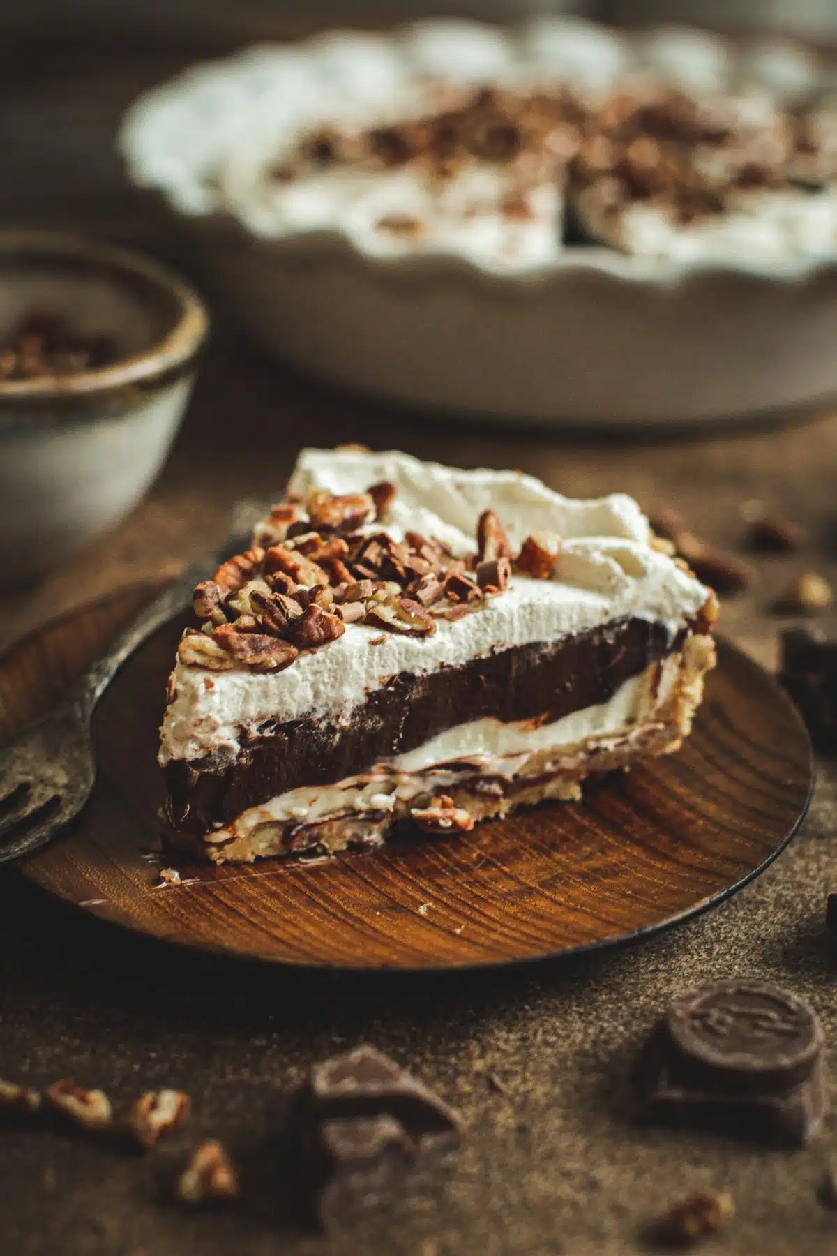 Slice of possum pie on a wooden plate.