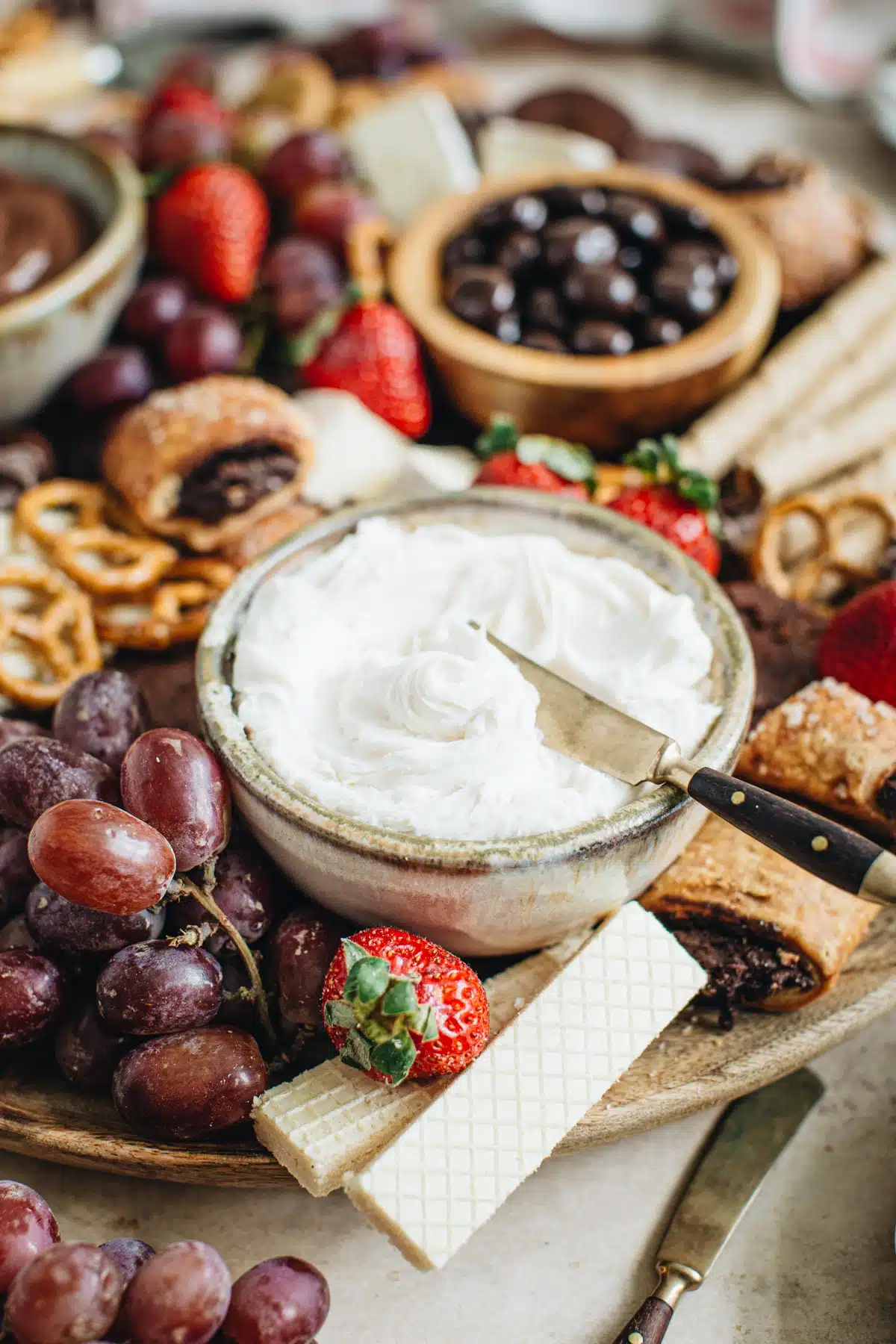 Close up of a dessert board with grapes, strawberries, and chocolates.