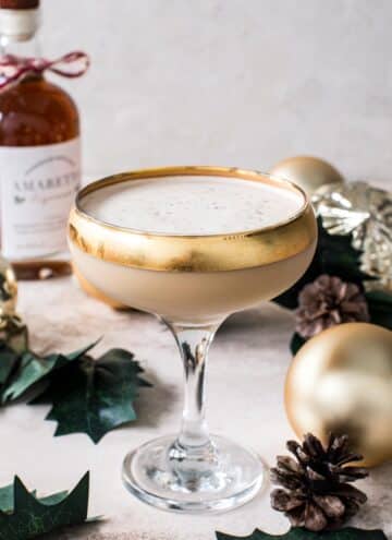 Toasted almond drink in a martini glass with a gold rim.