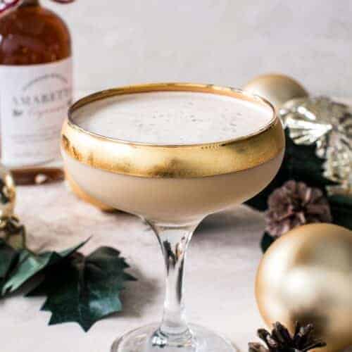 Toasted almond drink in a martini glass with a gold rim.