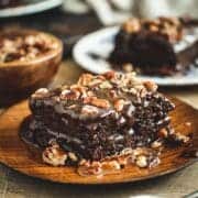 Slice of turtle cake on a wooden plate.