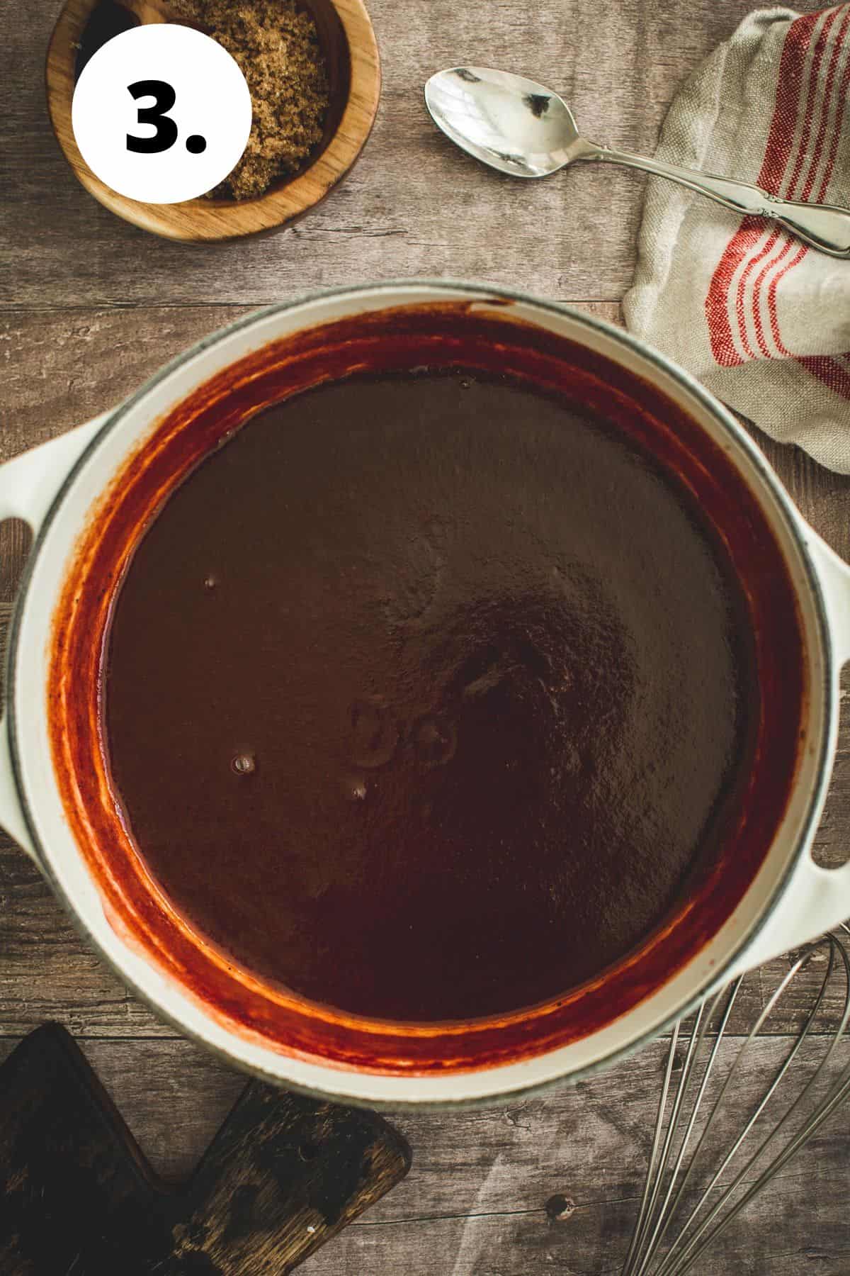 Thick bbq sauce in a white saucepan.