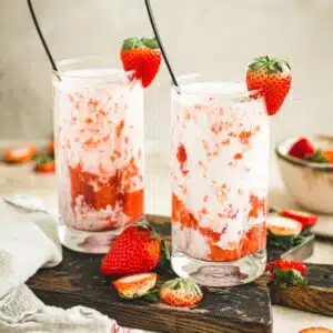 Strawberry milk in glasses with a strawberry garnish.