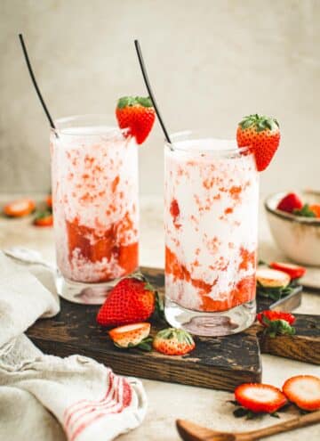 Strawberry milk in glasses with a strawberry garnish.