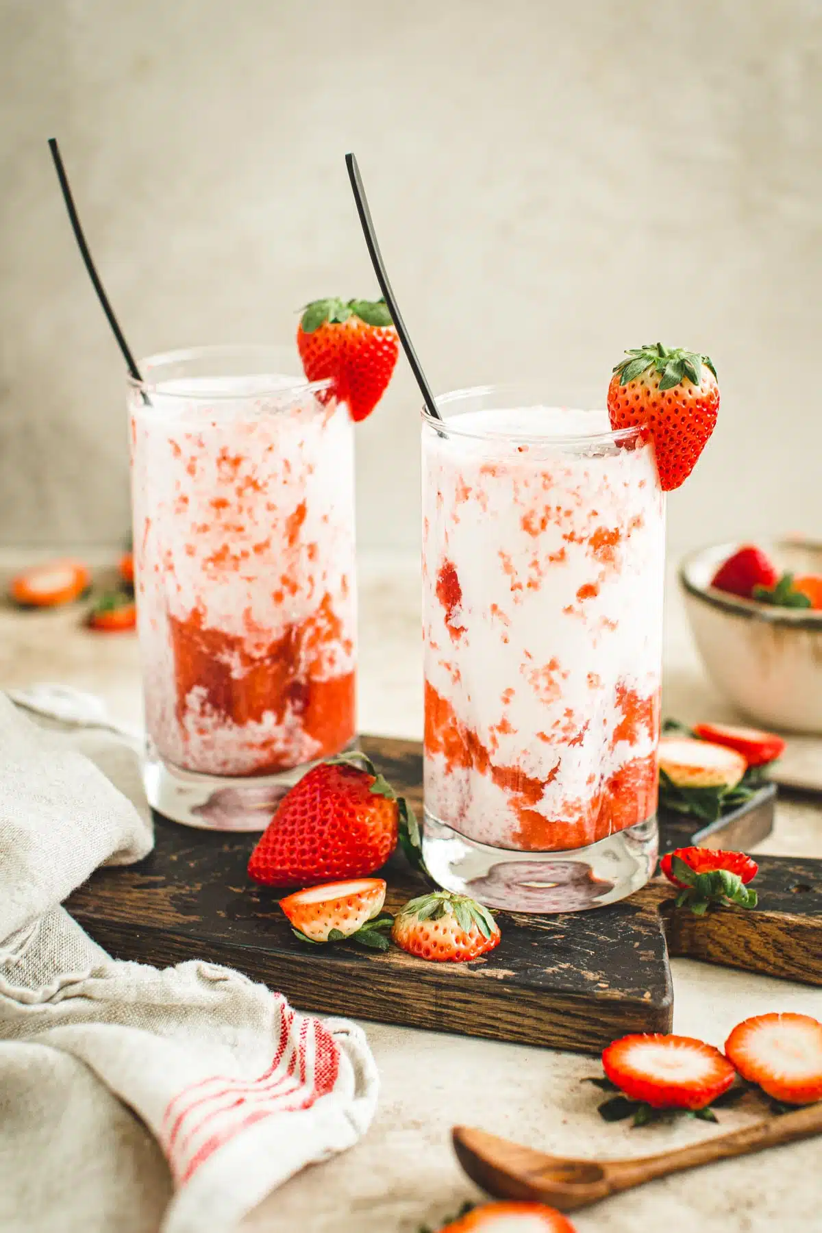 Strawberry milk in glasses with a strawberry garnish.