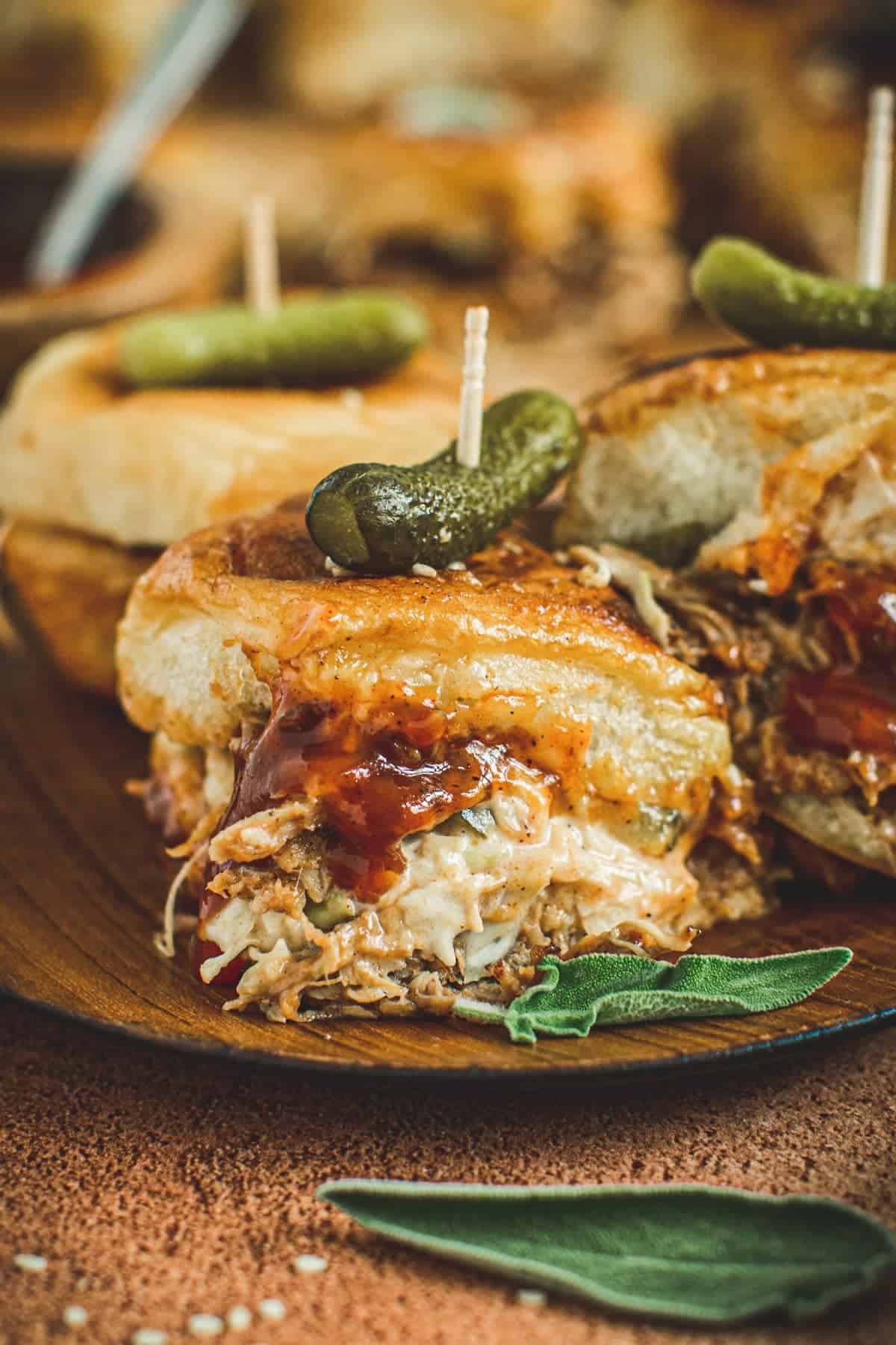 Pulled pork sliders on a wooden plate.