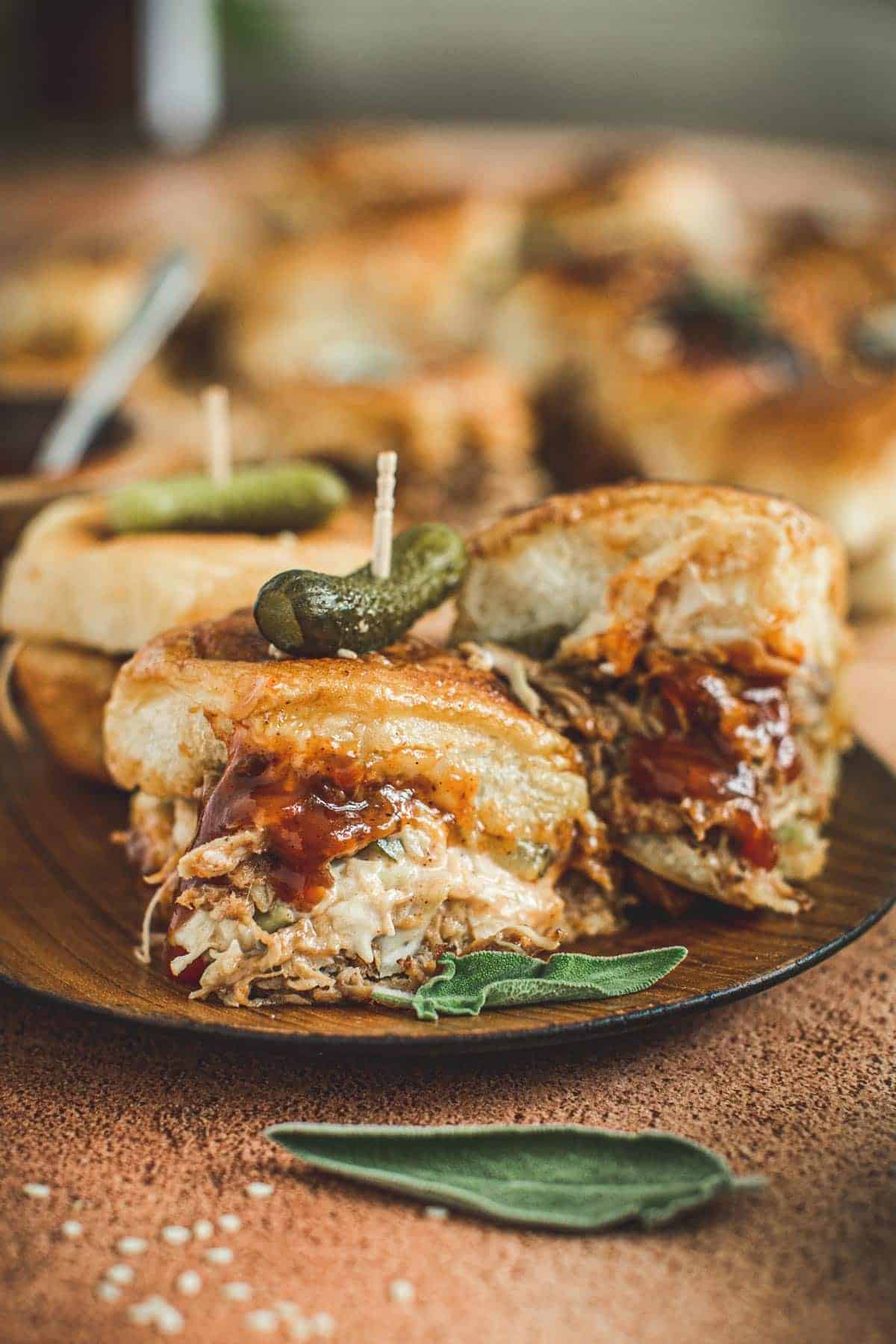 Pulled pork sliders on a wooden plate.