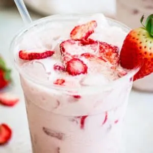 Starbucks pink drink topped with freeze-dried strawberries.