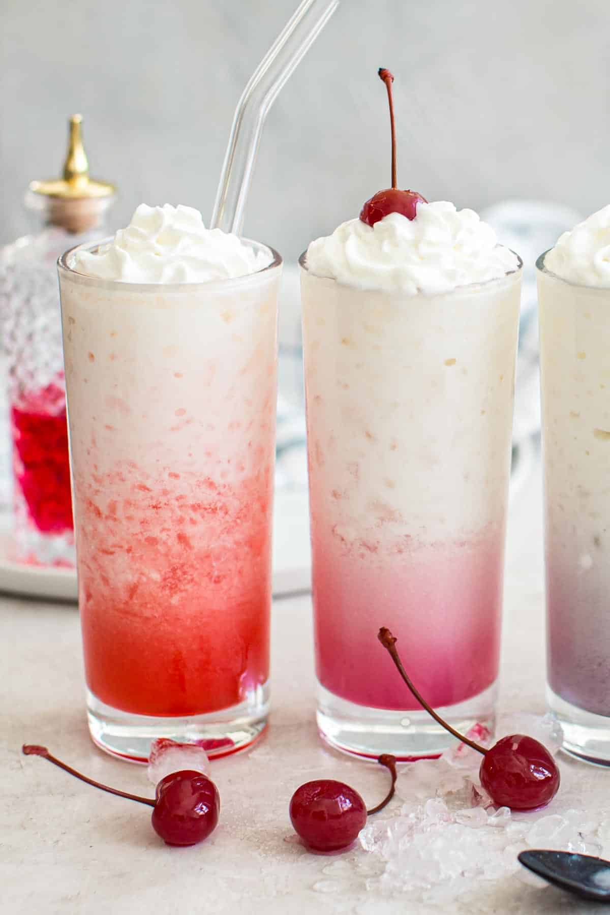 Two Italian sodas topped with whipped cream.