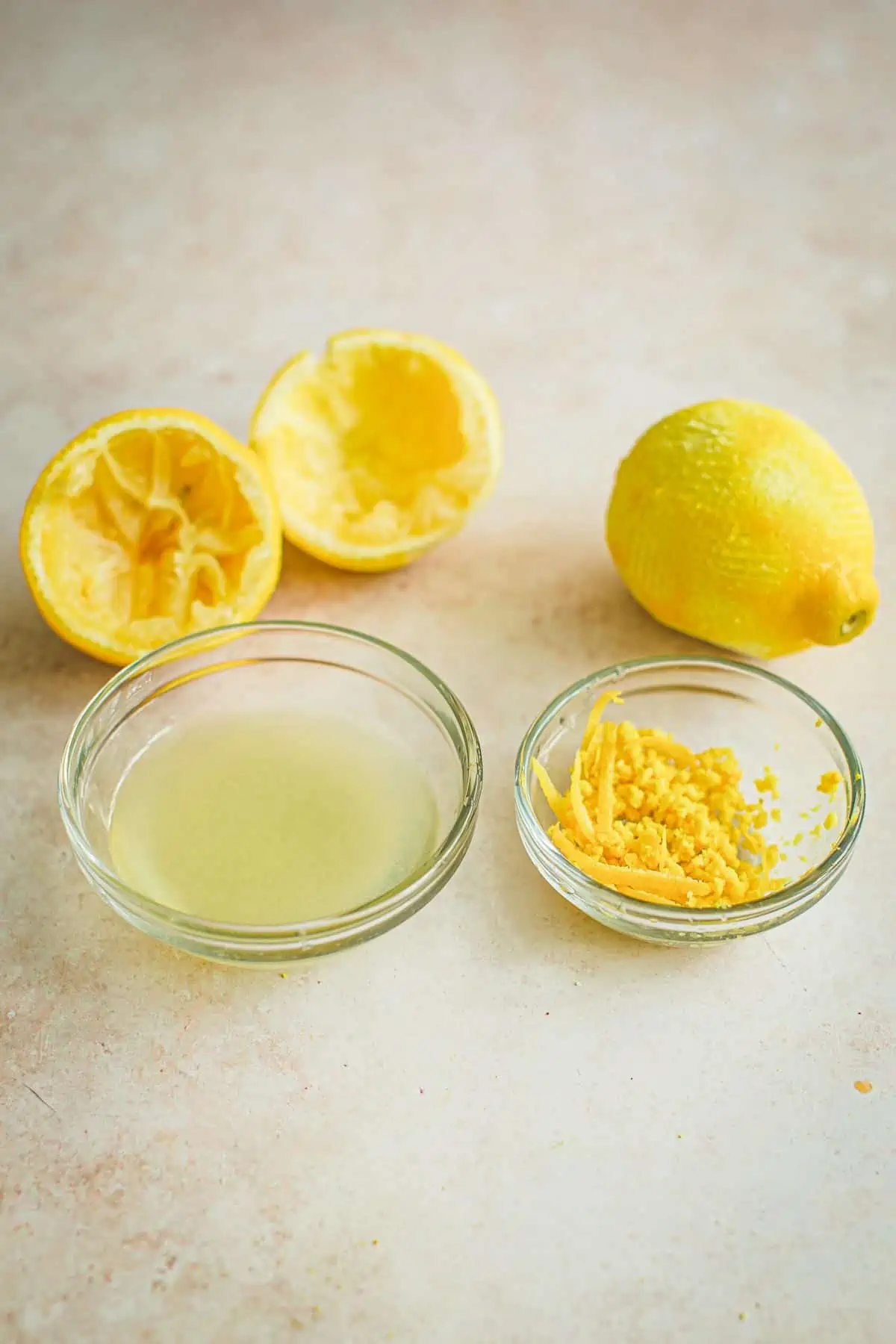 Bowl of lemon juice next to a bowl of lemon zest.