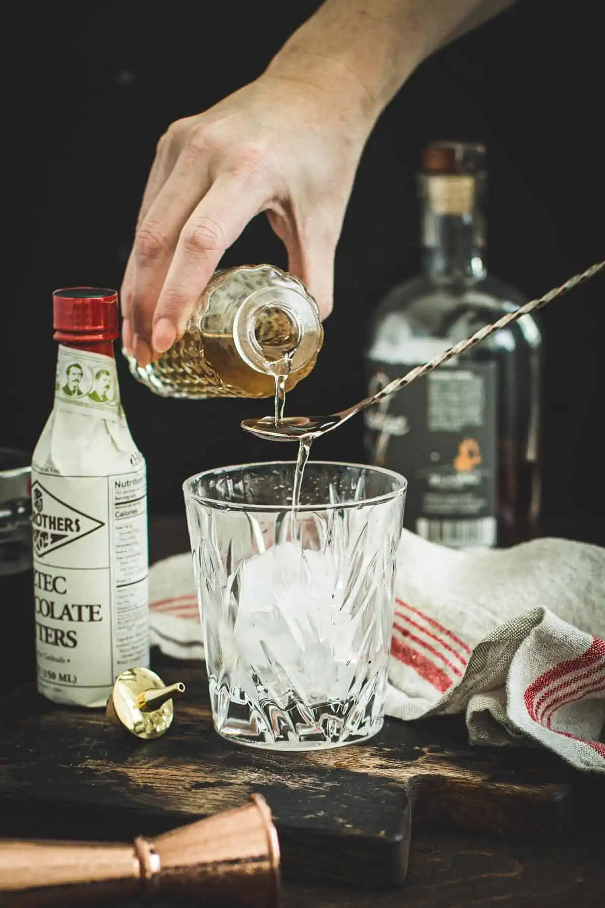 Homemade simple syrup pouring from a jar onto a spoon.