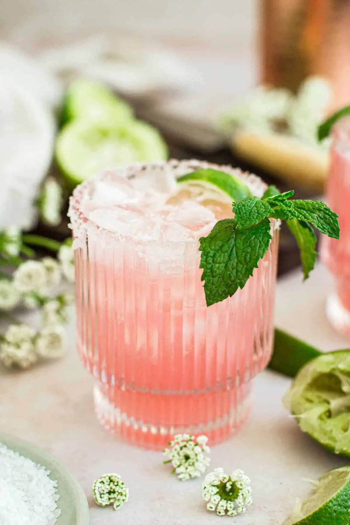 Pink margarita with a salted rim and fresh mint for garnish.