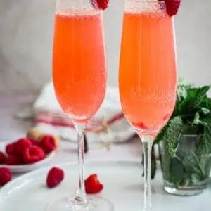 Two raspberry bellini cocktails on a tray.