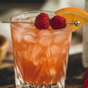 Raspberry sour cocktail with fresh raspberries for garnish.