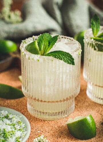 Rum margarita in a glass with a mint leaf.