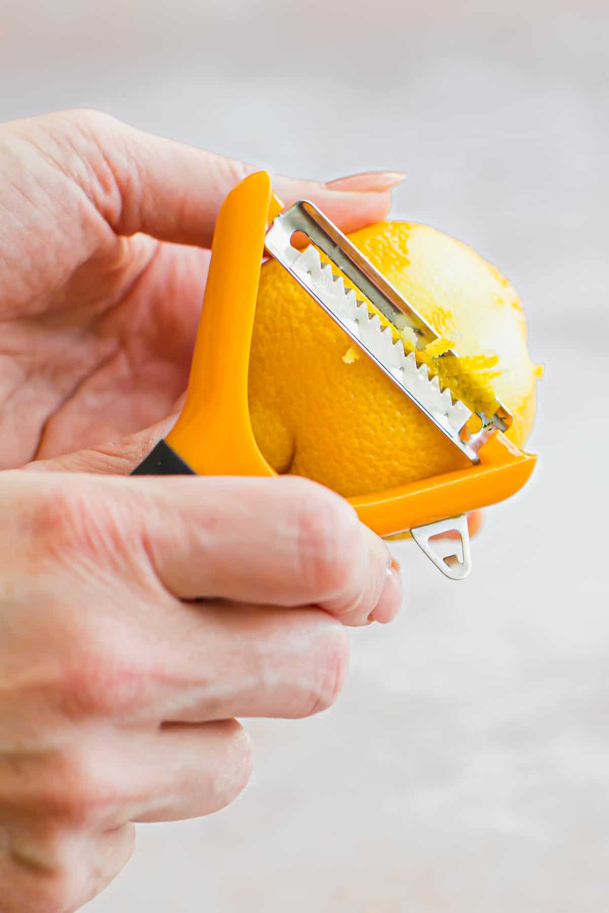 Zesting a lemon using a julienne peeler.