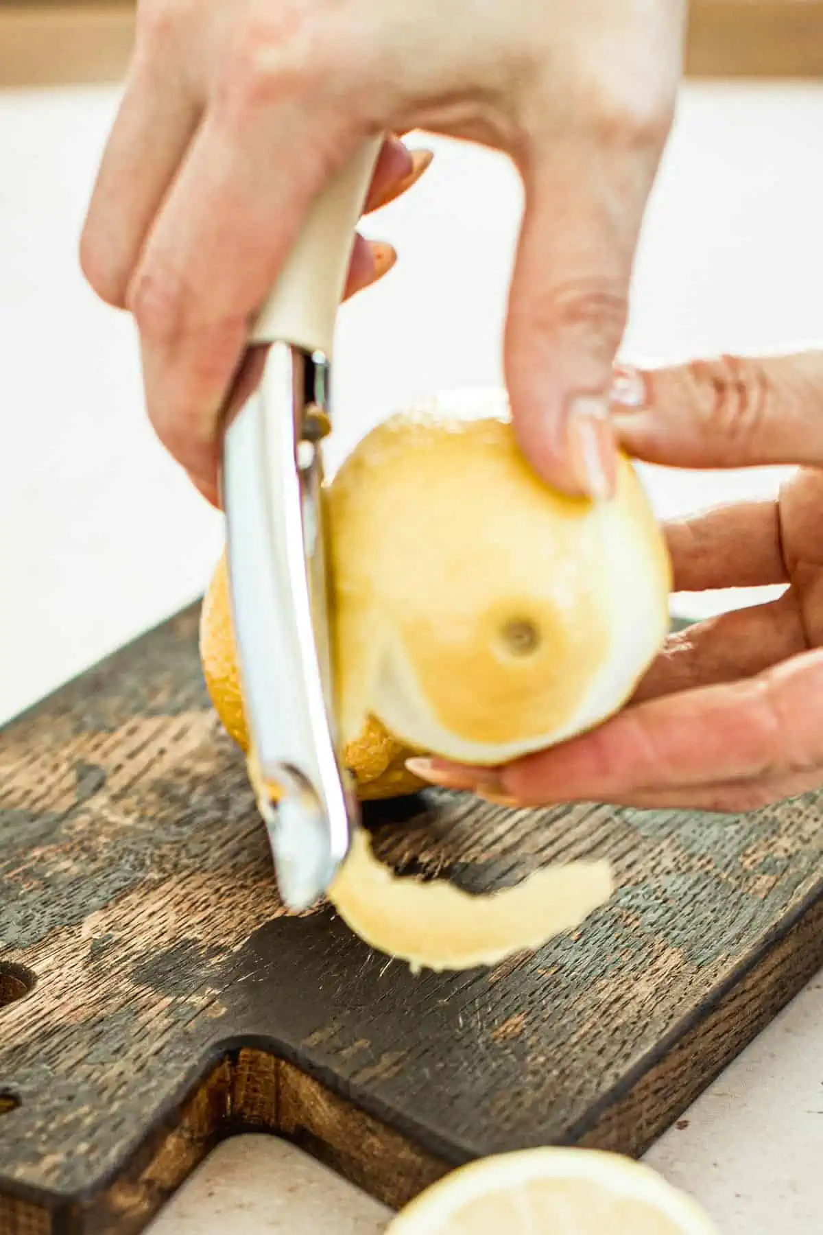 Zesting a lemon with a vegetable peeler.
