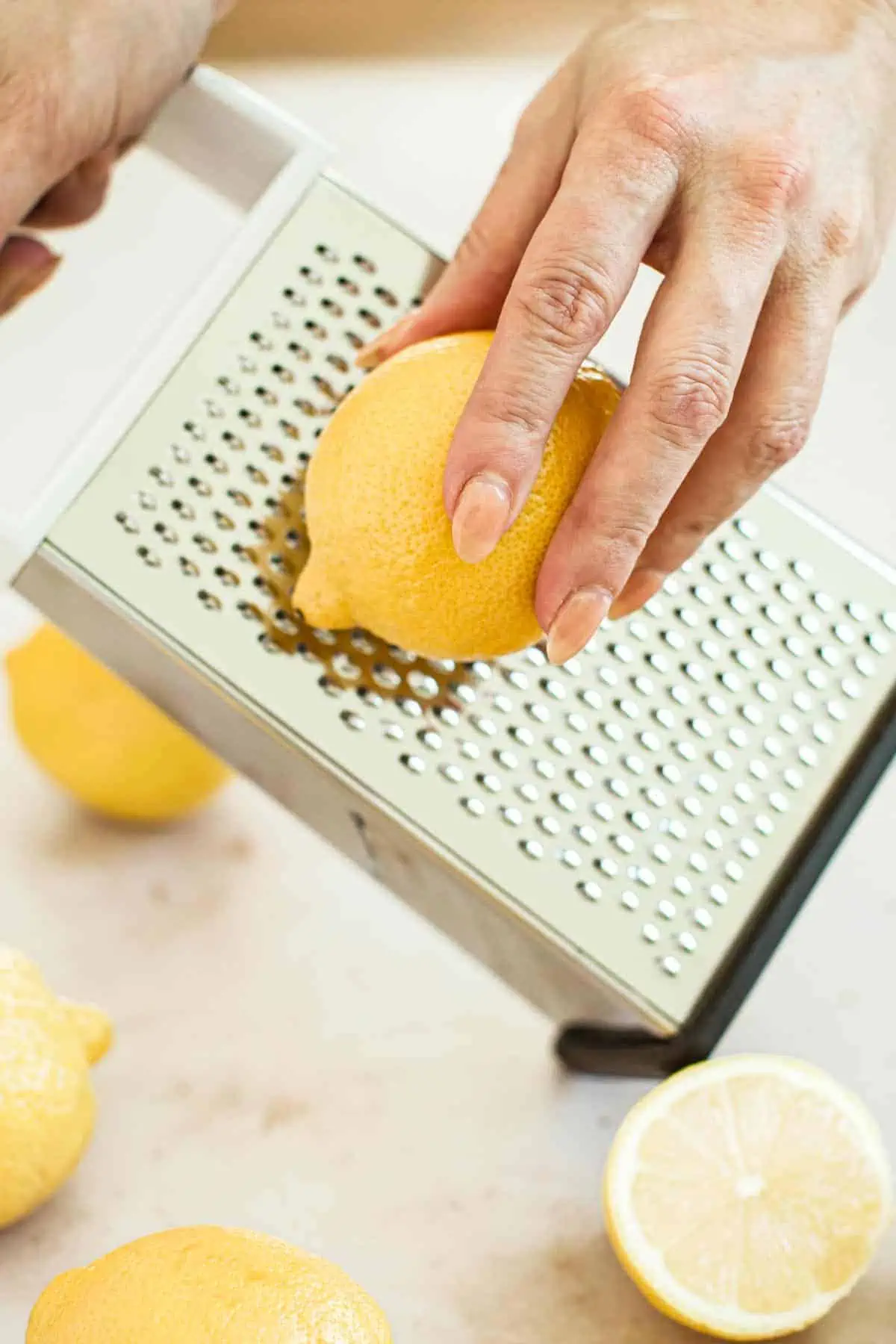 Using a cheese grater to zest a lemon.