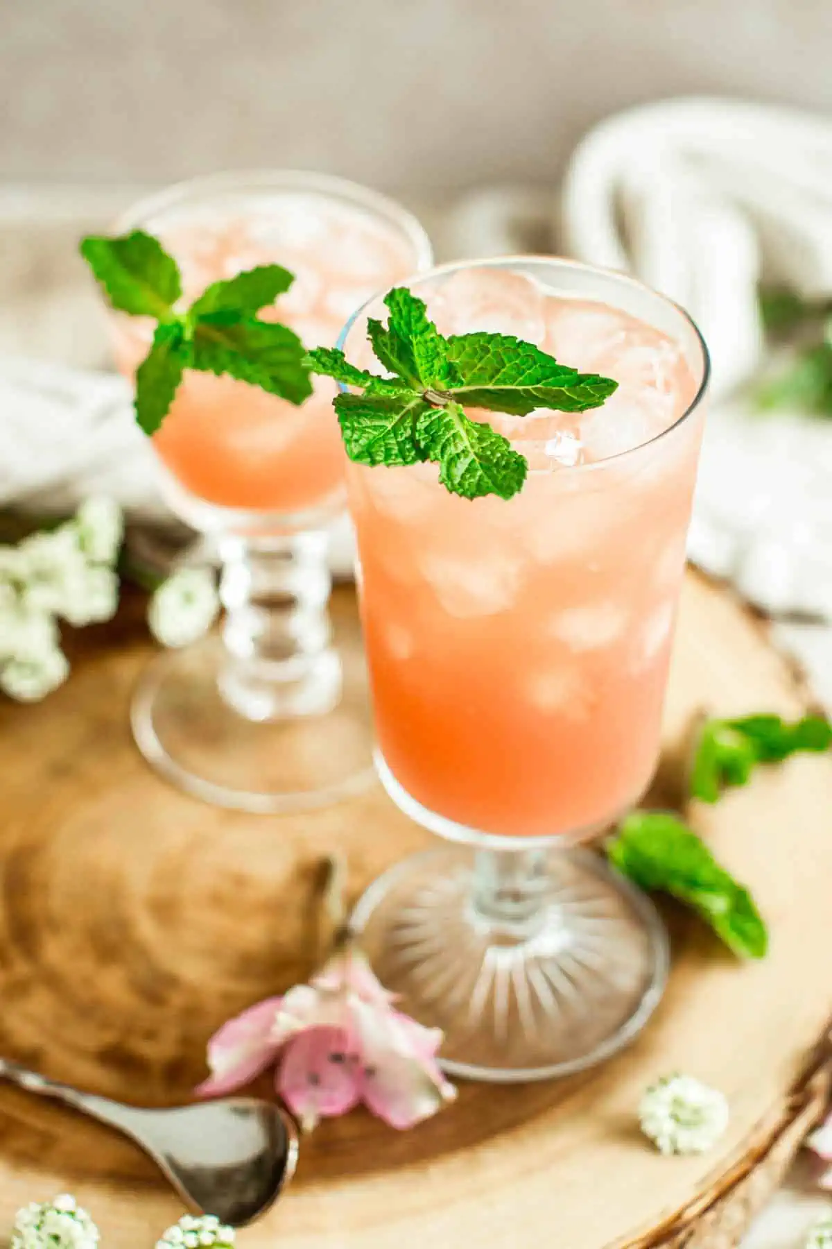 Two azalea cocktails topped with fresh mint leaves.