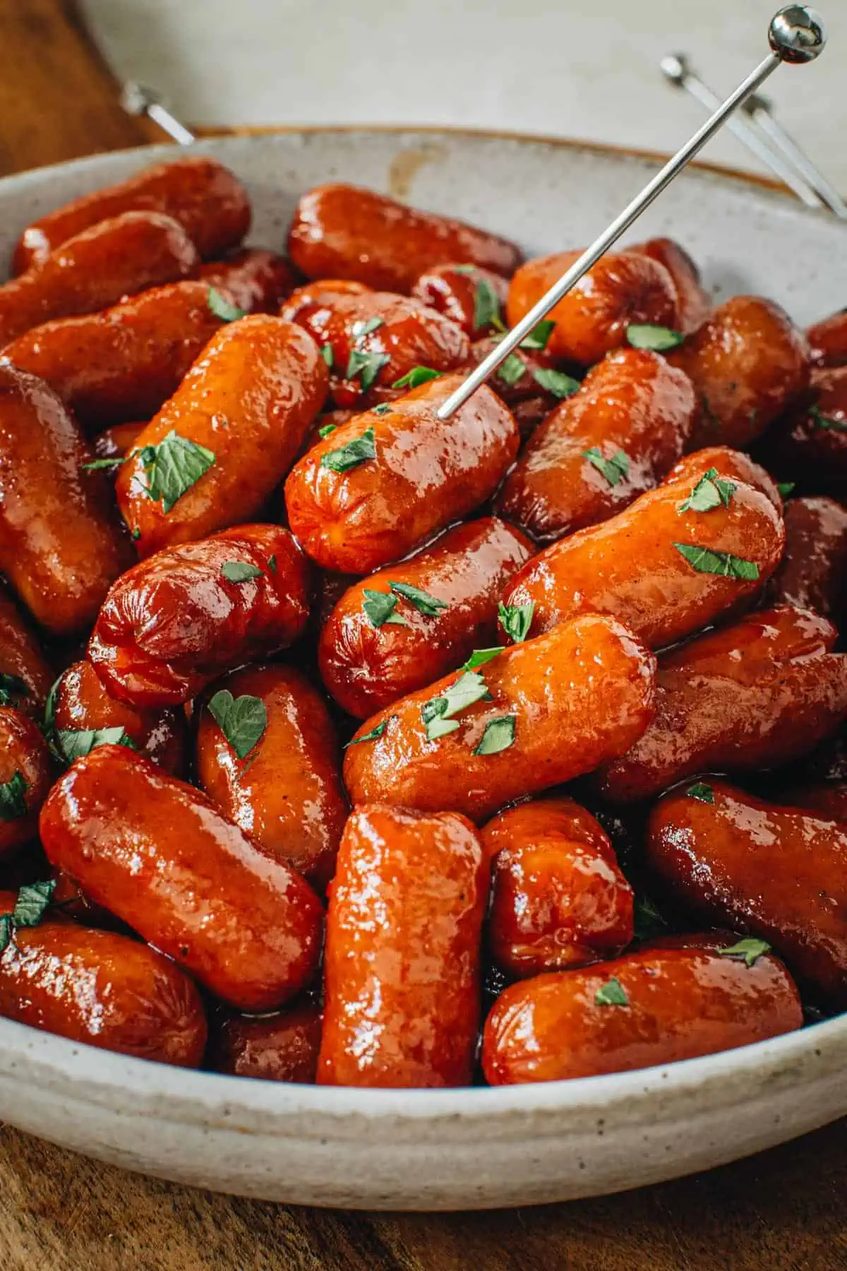 BBQ little smokies in a bowl topped with fresh cilantro.