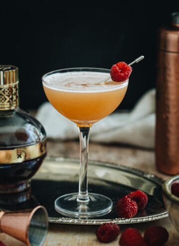 French Martini in a coupe glass with a fresh raspberry for garnish.