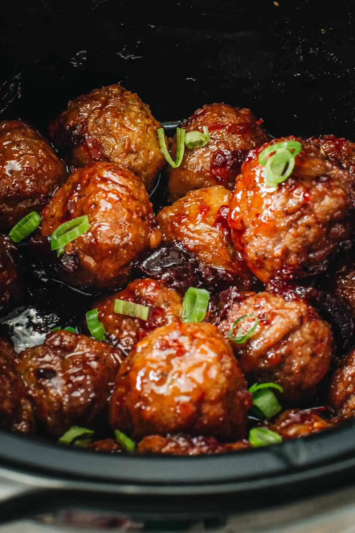 Crockpot full of meatballs with grape jelly and chili sauce.