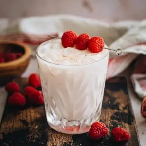 Nuts and berries drink garnished with raspberries.