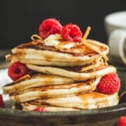 Maple syrup infused pancakes topped with fresh raspberries.