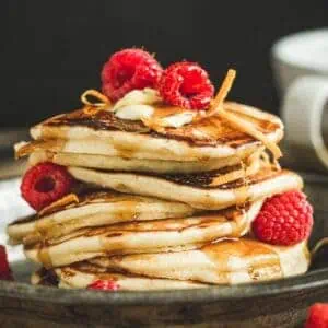 Maple syrup infused pancakes topped with fresh raspberries.