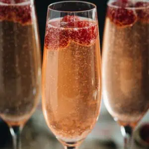 Raspberry champagne cocktails in champagne flutes.