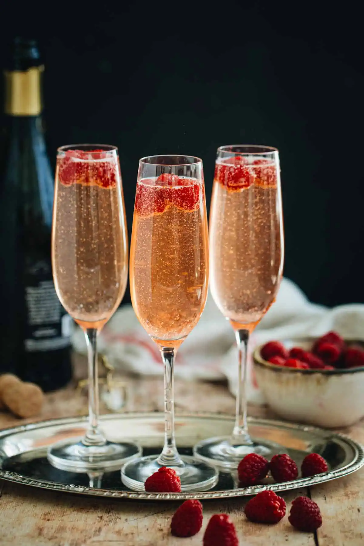 Raspberry champagne cocktail with fresh raspberries as a garnish.