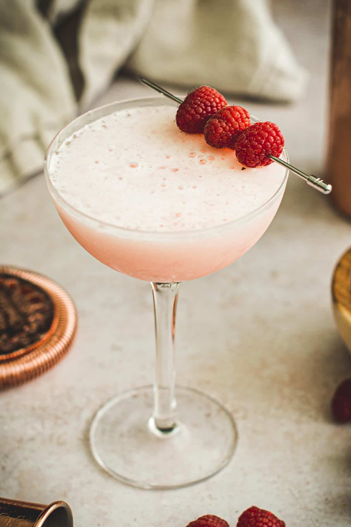 Raspberry cocktail in a coupe glass.